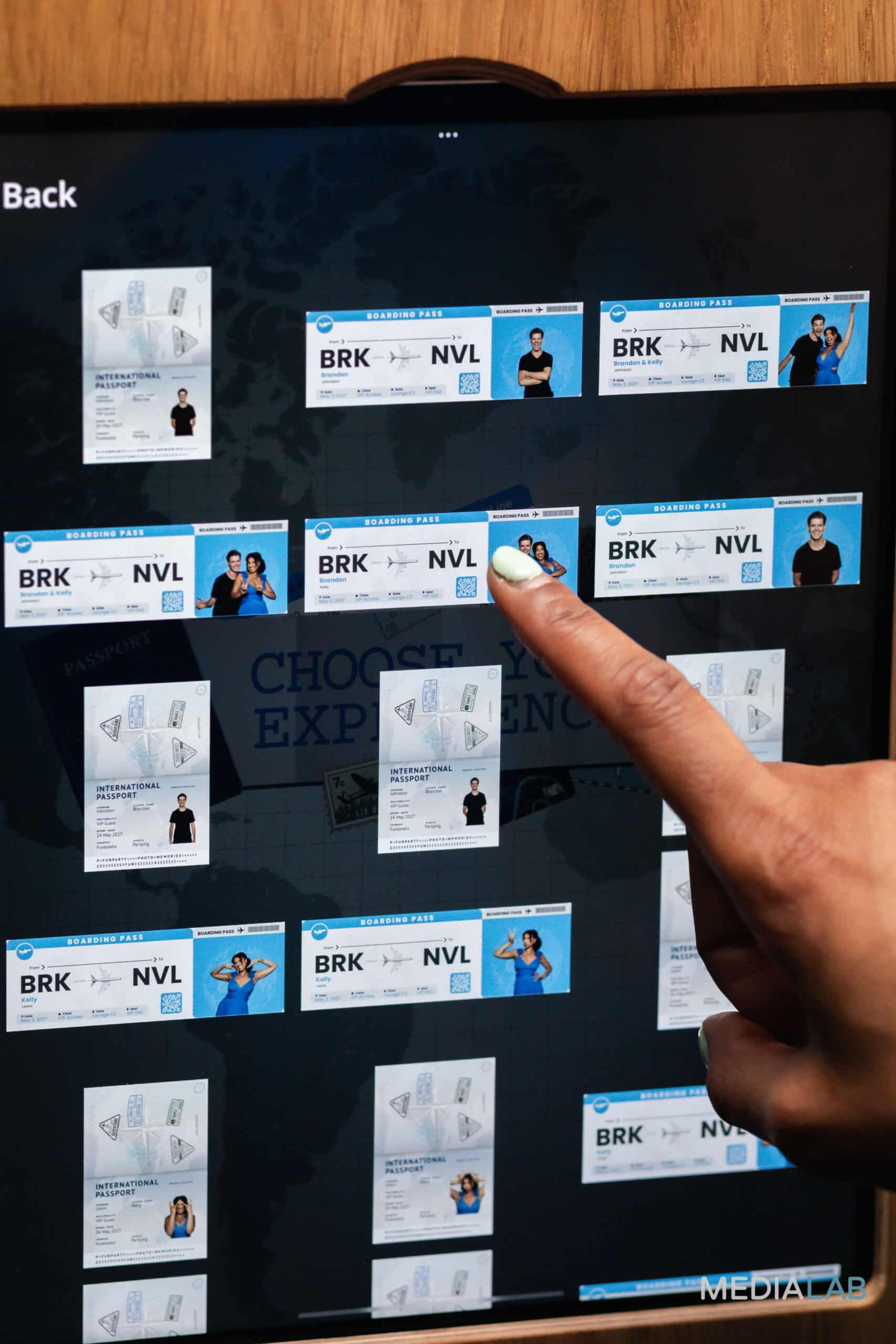 Person interacting with a touchscreen displaying various boarding passes and international passports, highlighting customization options for event photo booth experiences.